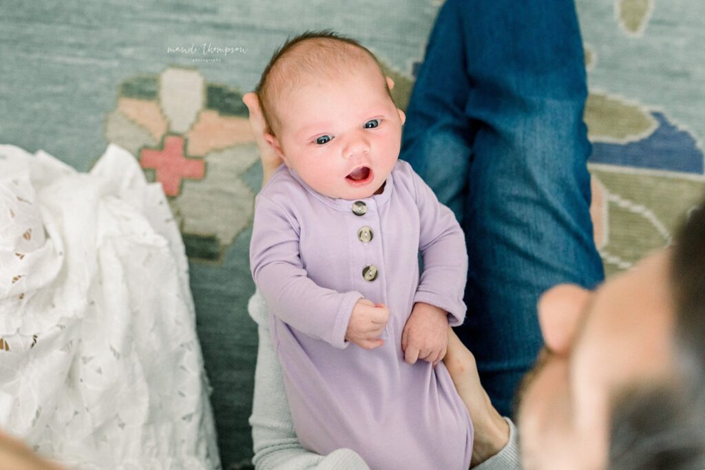 beautiful newborn baby with stunning colorful rug as background