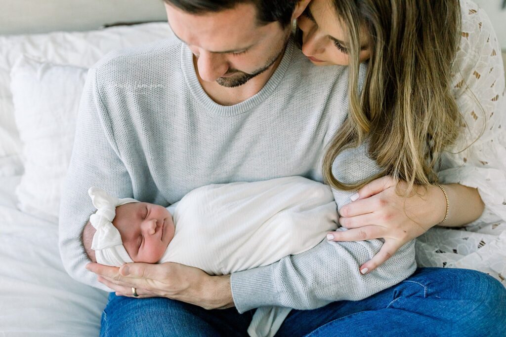 Mom and Dad admiring their beautiful baby during their in-home newborn session with Mandi Thompson Photography