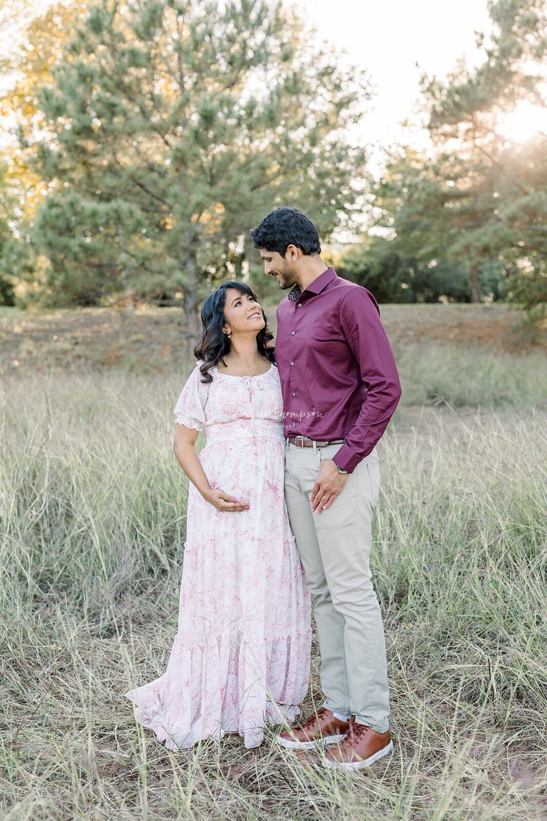 Mom laughing while partner smiles during luxury maternity photos Katy TX