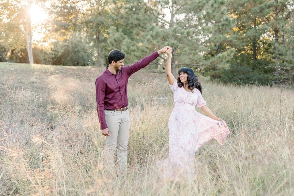 parents to be having fun in a field during maternity session in katy texas