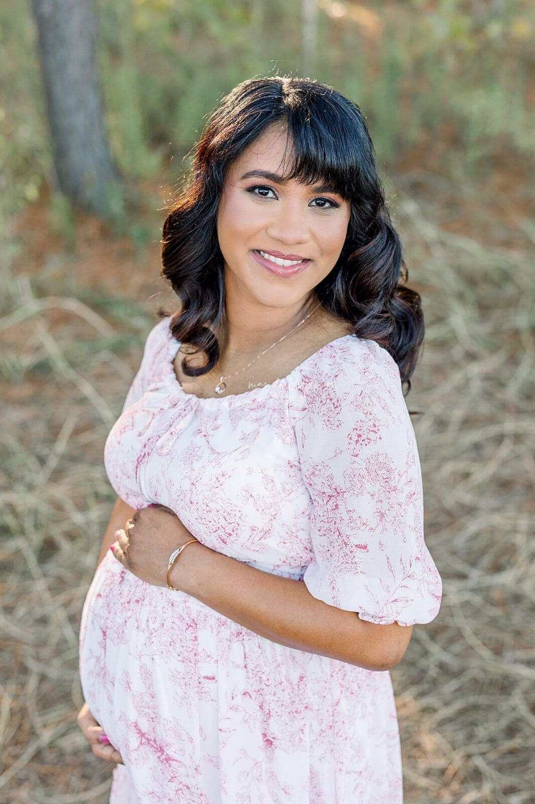 expecting mother holding baby bump in katy texas during maternity session
