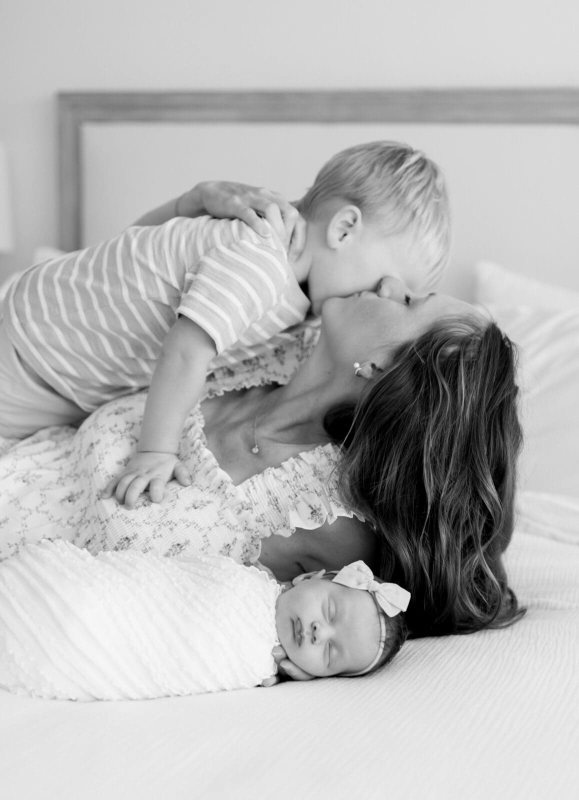 Mom snuggling newborn baby and toddler in natural light Katy Texas home