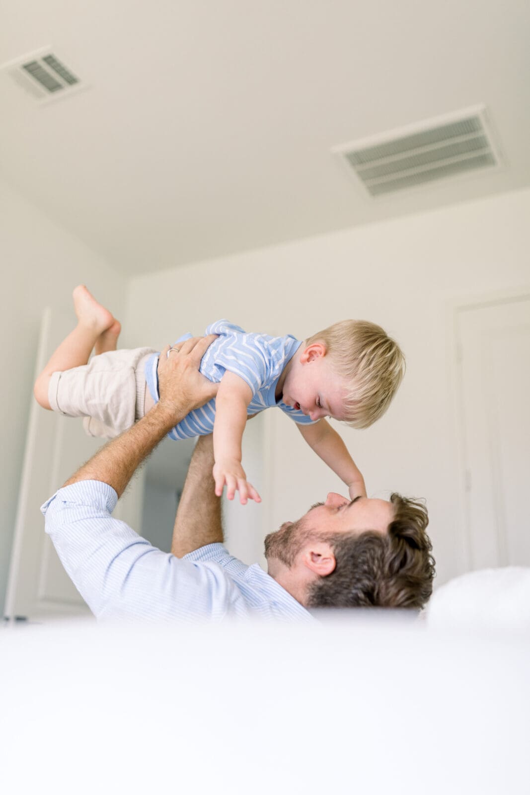 father playing with toddler during family newborn portraits 
