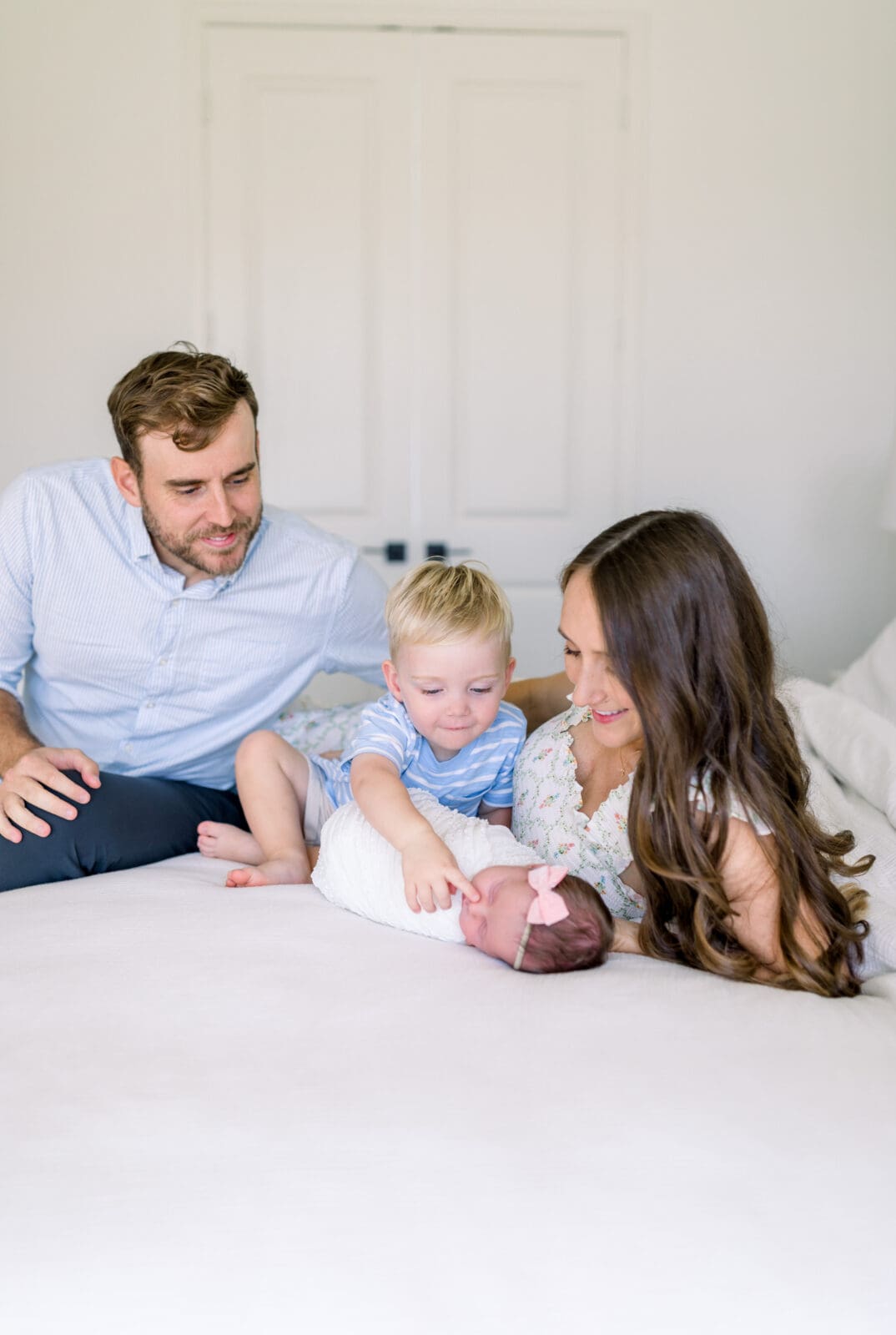 Family cuddling on bed during lifestyle newborn session Katy TX