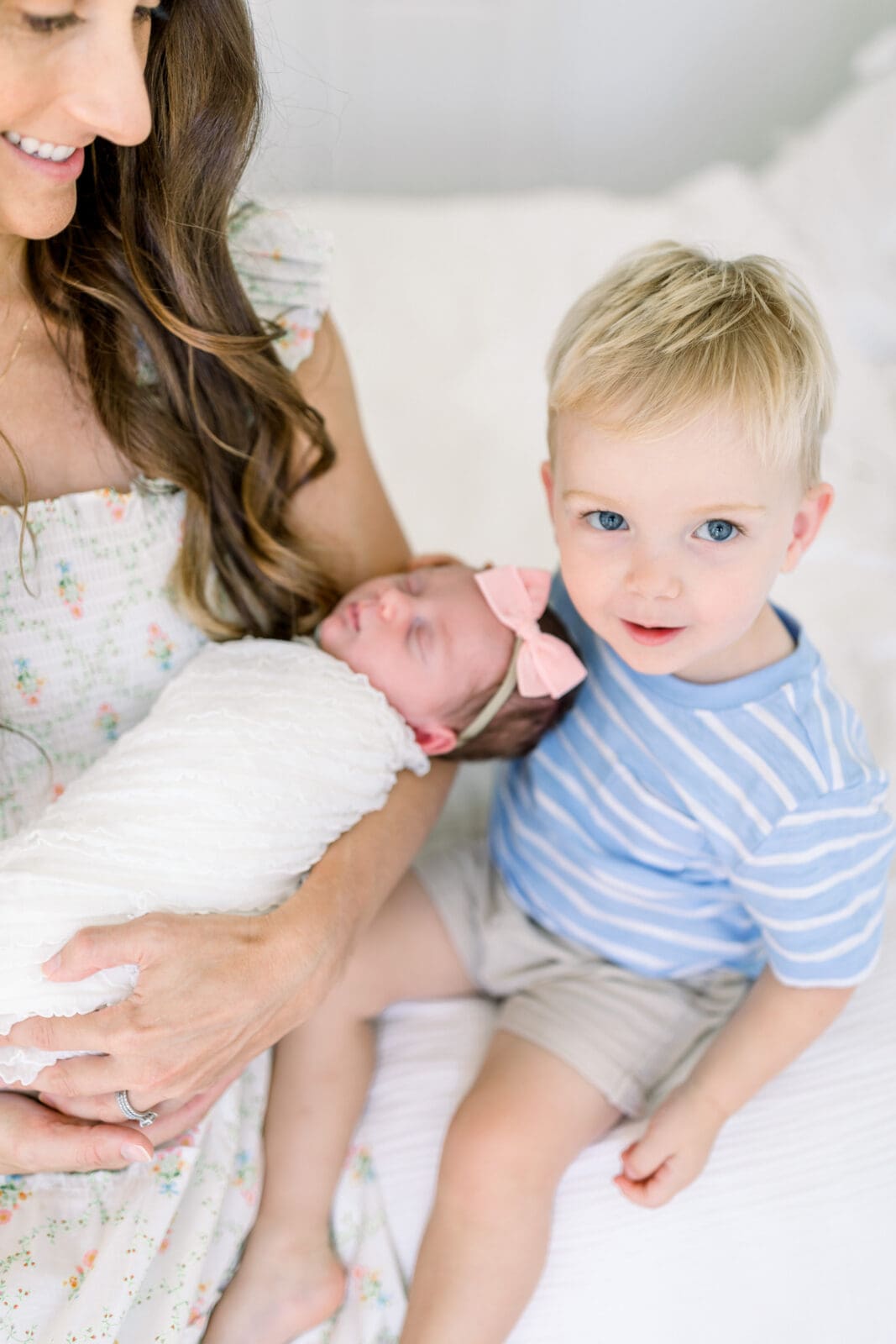 Toddler sitting beside parents and newborn in Katy TX home