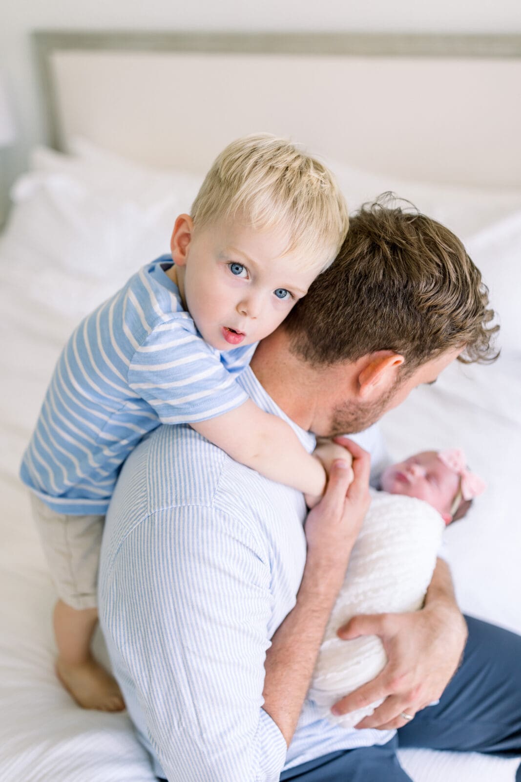 Dad snuggling with newborn & toddler during lifestyle session in Katy TX