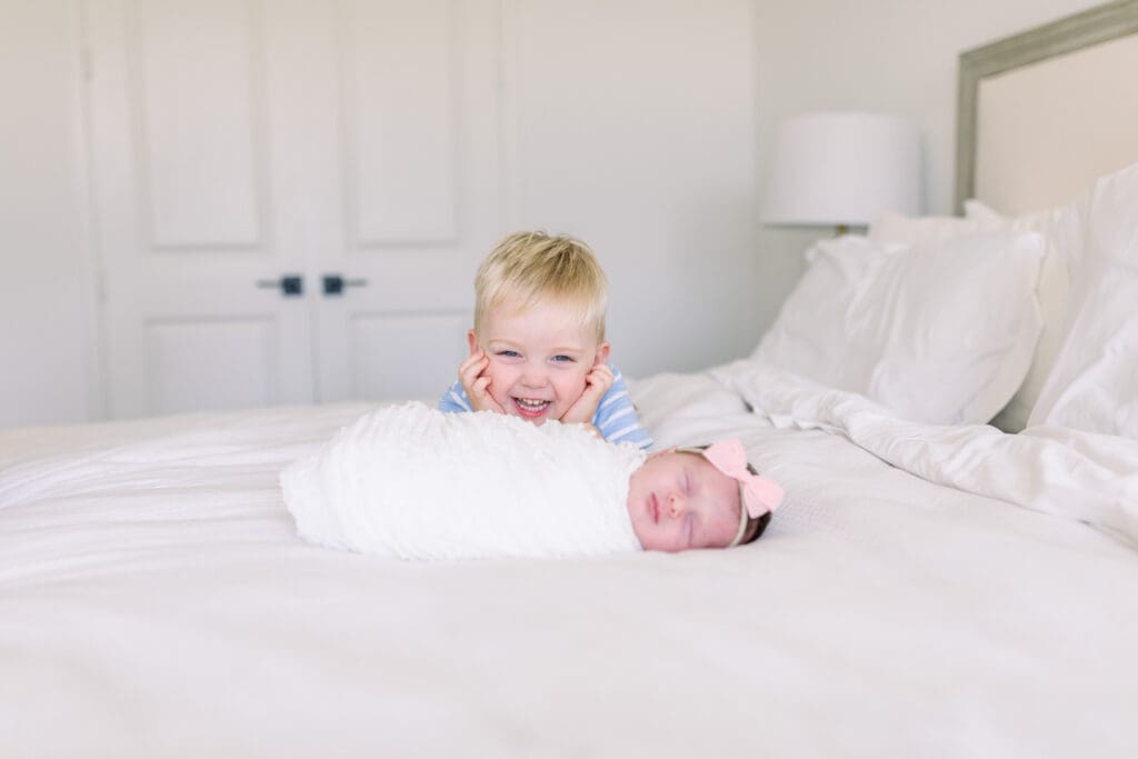 Toddler holding newborn during in-home lifestyle session Katy TX