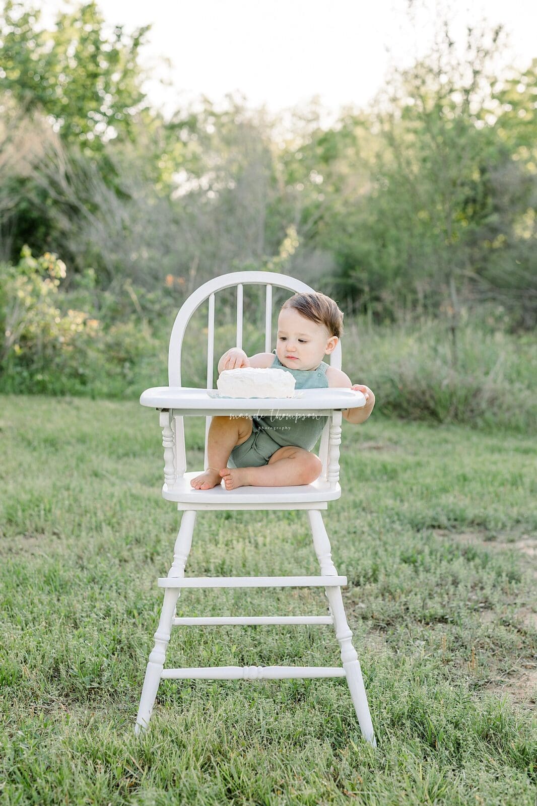 Baby cake smash in a vintage high chair with neutral tones
