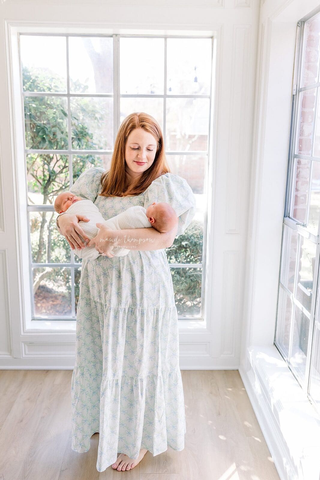 Mom holding newborn twin babies in living room Katy TX