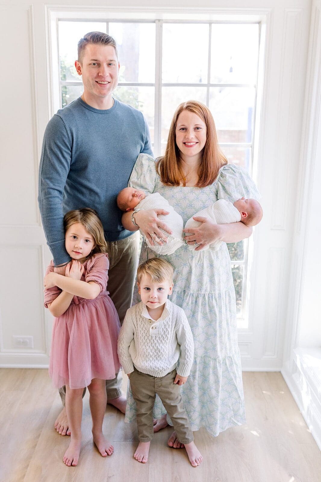 Family cuddling newborn in living room Katy TX