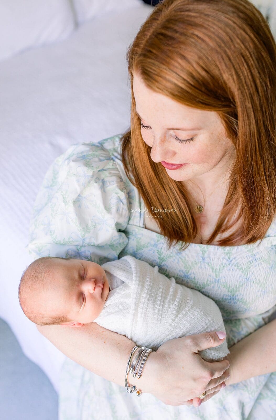 Mom holding newborn baby in master bedroom Katy TX